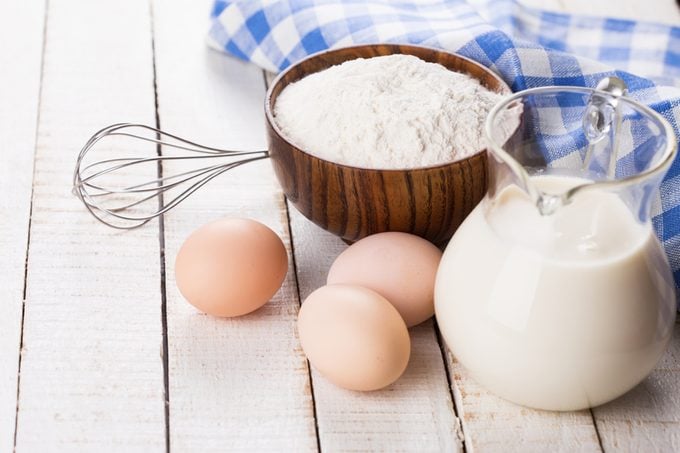 Ingredients for pancakes - eggs, flour, milk on white wooden background. Selective focus.; Shutterstock ID 167598458; Job (TFH, TOH, RD, BNB, CWM, CM): Taste of Home