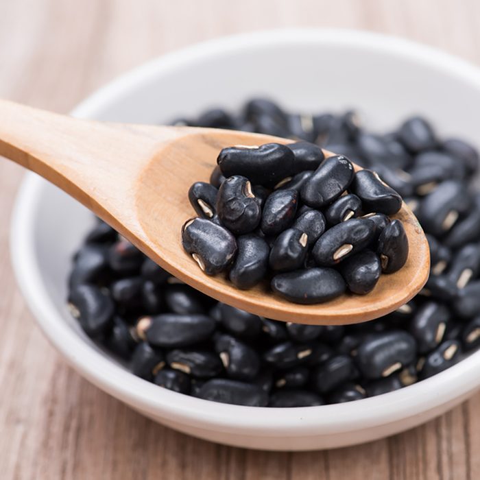 Black Beans in wooden spoon with ceramic bowl