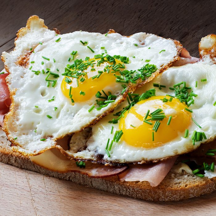 Slice of rustic bread with ham or bacon and fried egg