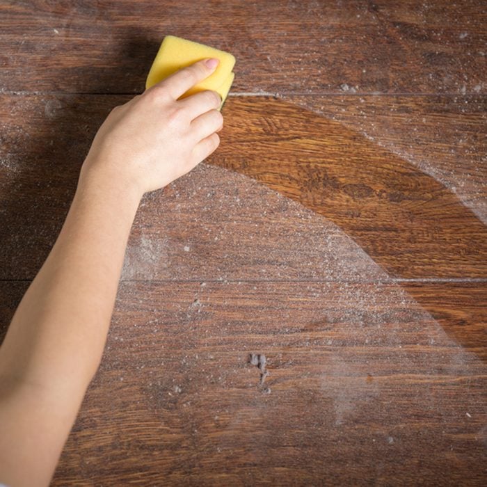 Using yellow sponge for cleaning dusty wood; Shutterstock ID 273329774