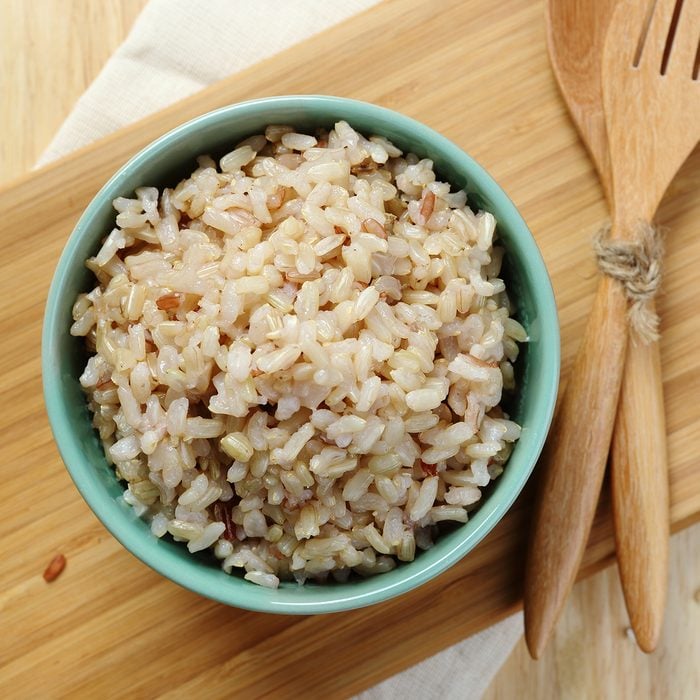 Organic Brown Rice in the bowl on the wooden table; Shutterstock ID 280020284