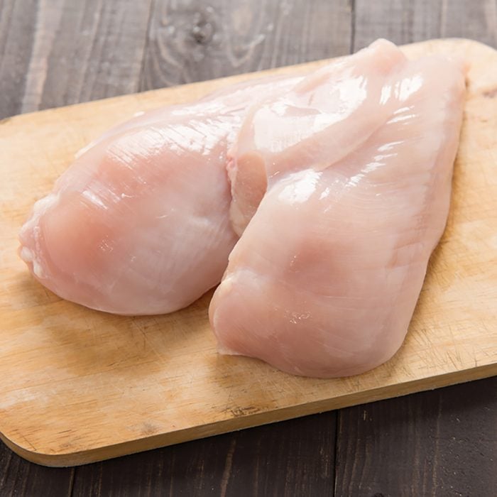 Raw chicken breast fillets on wooden background