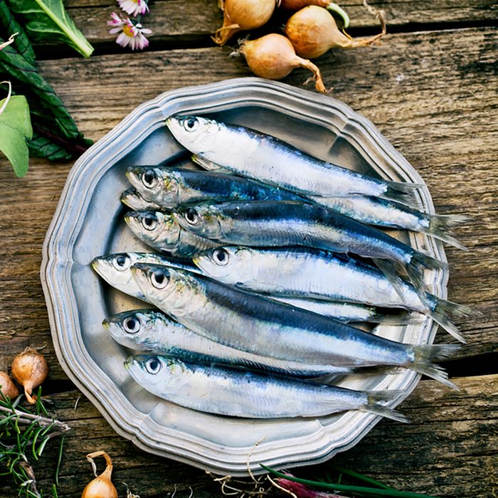 Fresh sardines. Fish with vegetables. Mediterranean fish on plate