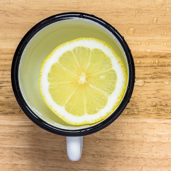 Lemon slice in water in a steel mug view from above