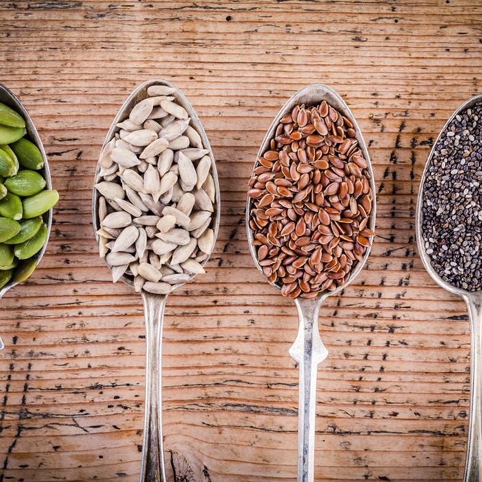 Healthy superfood: pumpkin seeds, sunflower seeds, flax seeds and chia on wooden table