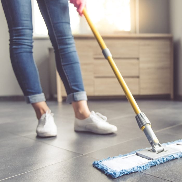 Cropped image of beautiful young woman in protective gloves using a flat wet-mop while cleaning floor in the house; Shutterstock ID 510917479