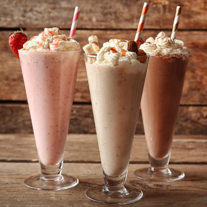 Delicious milkshakes on wooden background