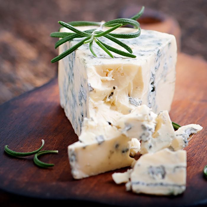 Blue cheese on the old wooden background.