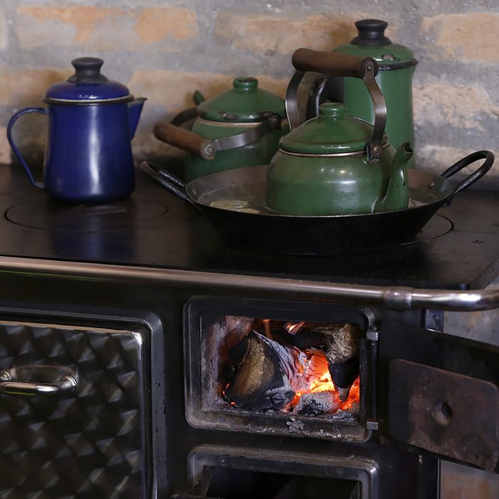 warm fire heating a coffee kettle in wood burning stove. Traditional style in countryside of Brazil