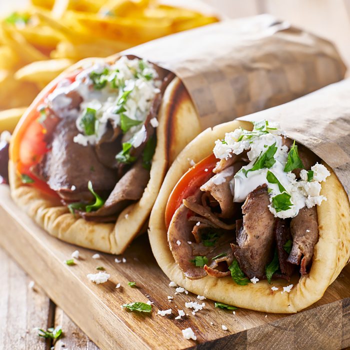 greek lamb meat gyros with tzatziki sauce, feta cheese and french fries