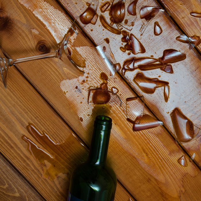 Broken wine glass with bottle on wooden table
