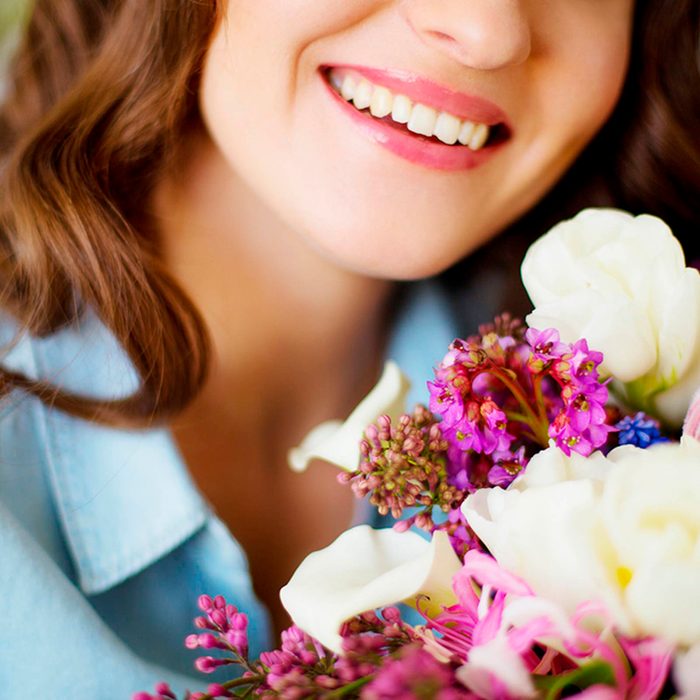 Woman smiling while holding flowers