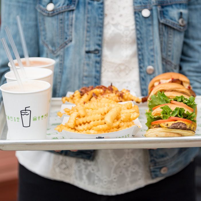 Person carrying tray of Shake Shack food