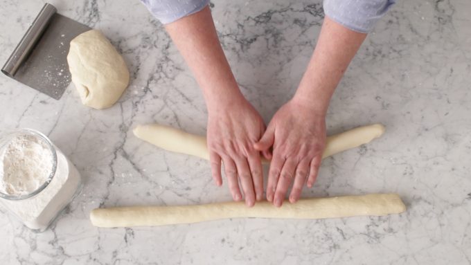 Person rolling bread dough with their hands