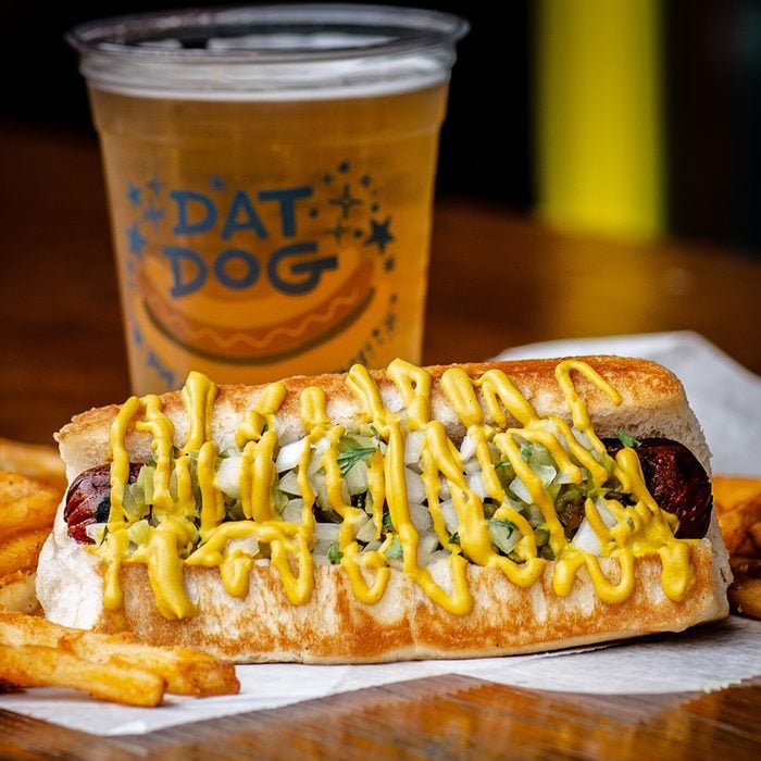 Dat Dog hotdog beside a drink