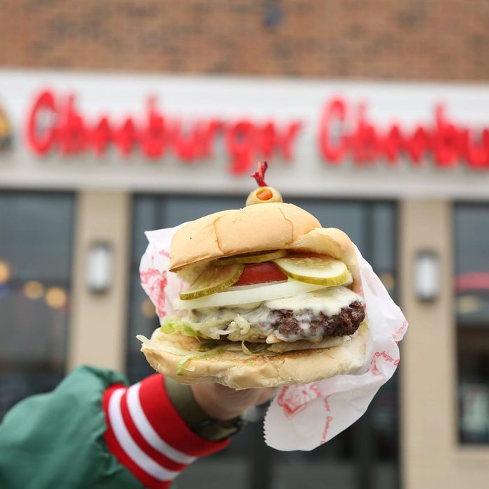 Person holding up a cheeseburger