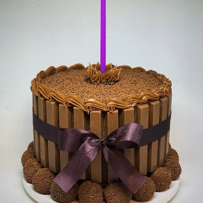 Cake with its sides covered in Kit Kat bars