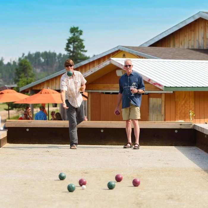 Two men enjoying a ball toss game and wine at Miner Brewing