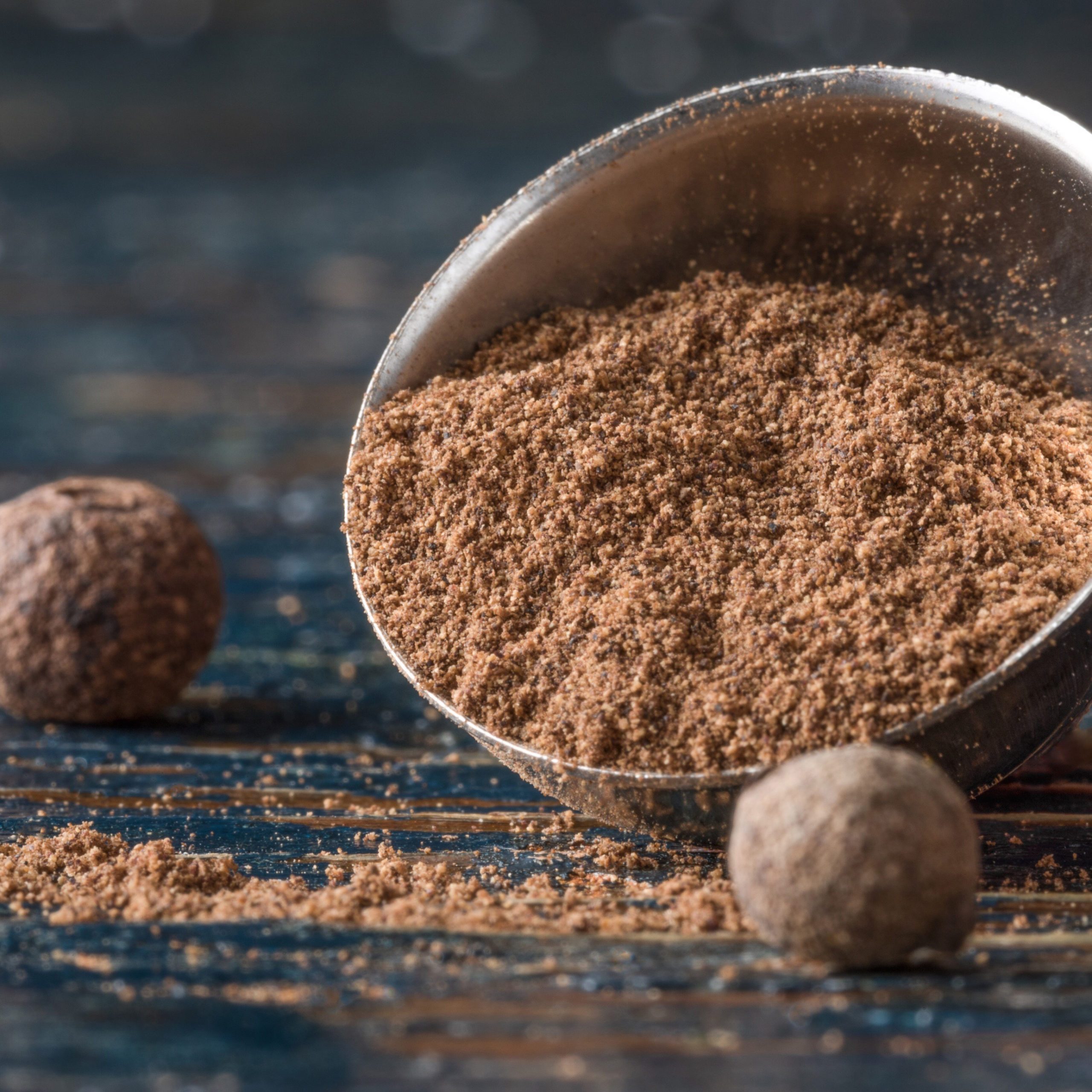 Close-Up Of Ground Allspice In Measuring Spoon Wooden Table