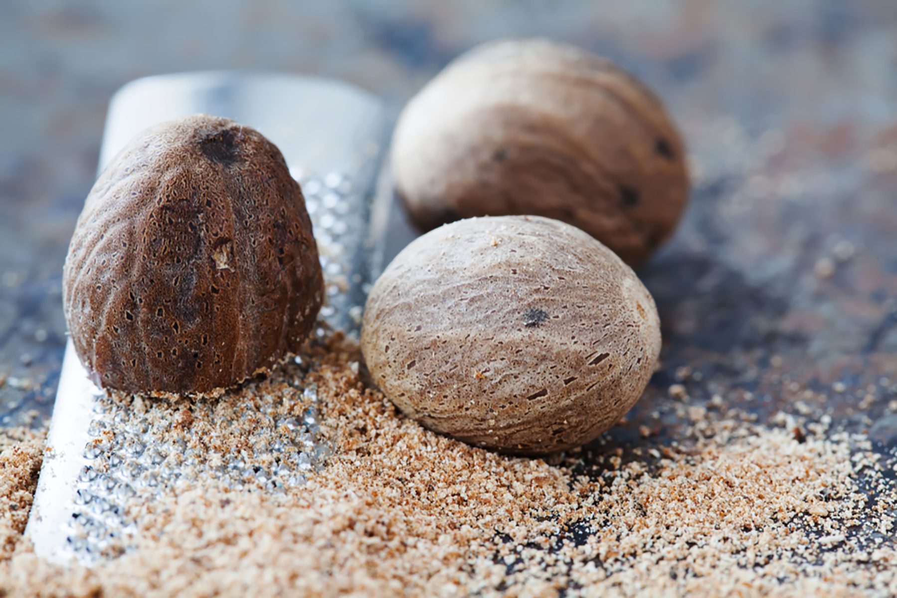 Making nutmeg powder process. Nuts silver grater. Kitchen still life photo. Shallow depth of field, aged brown rusty background. Selective focus.; Shutterstock ID 1059835649