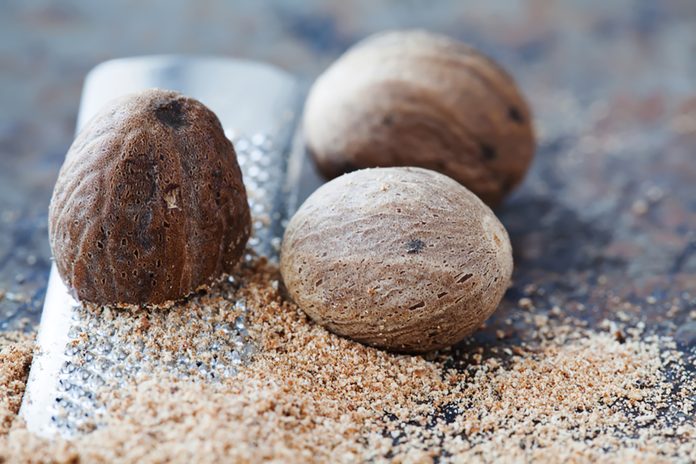 Making nutmeg powder process. Nuts silver grater. Kitchen still life photo. Shallow depth of field, aged brown rusty background. Selective focus.; Shutterstock ID 1059835649