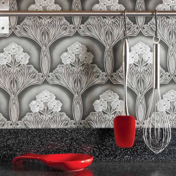 Kitchen with a grey, patterned wallpaper as its backsplash