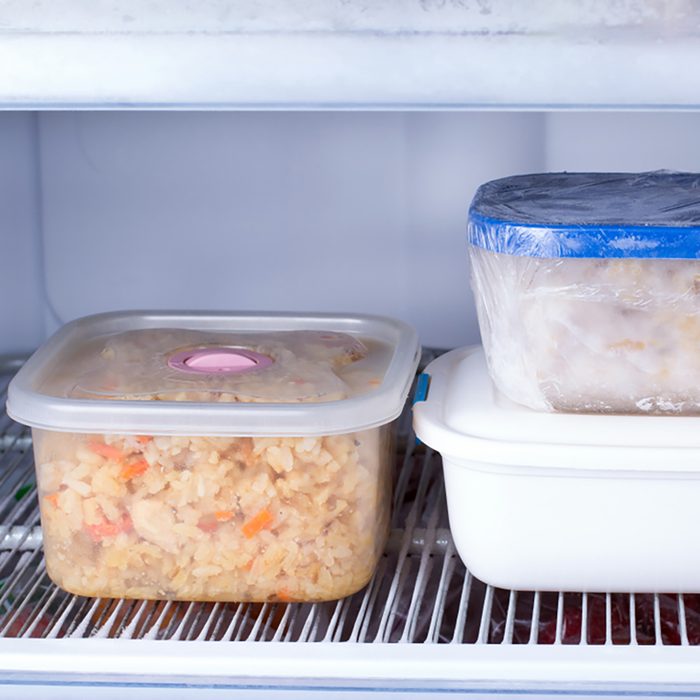 Frozen food in a container in the freezer. Refrigerator with frozen food. Ready meal; 