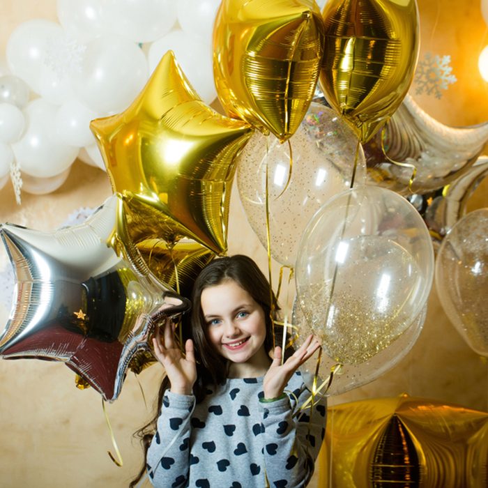 Little girl smile with golden silver star balloons