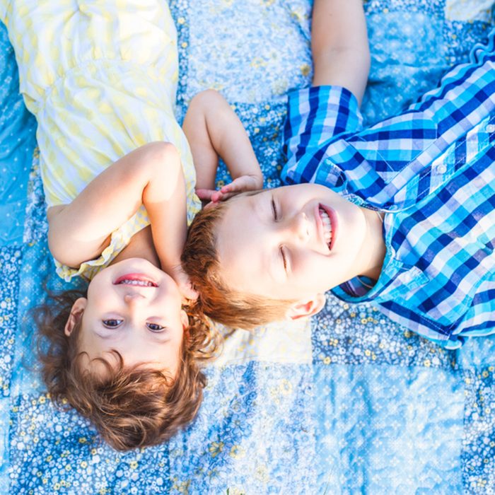 Two children lying on blanket