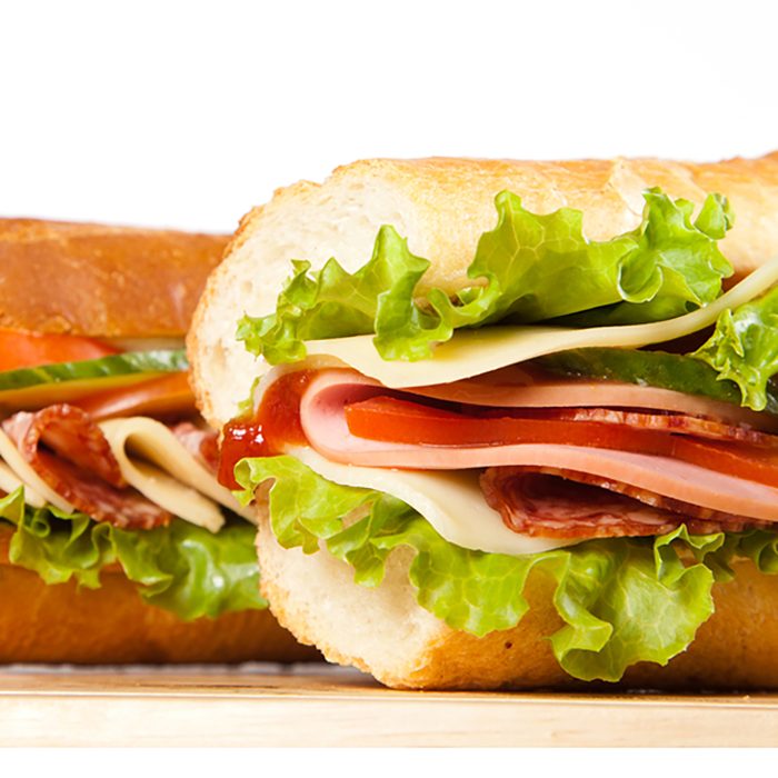 big sandwich with fresh vegetables on wooden board