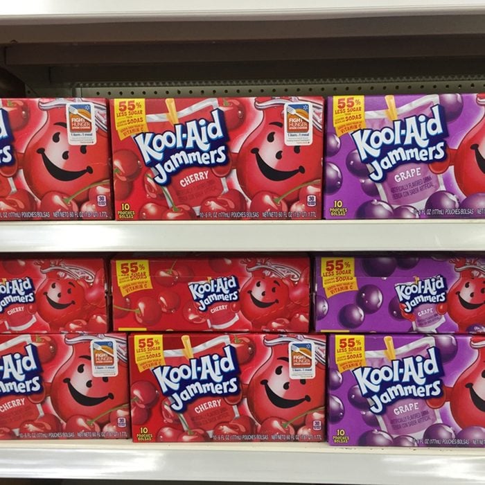 Several boxes of Kool-Aid on a modern grocery store shelf