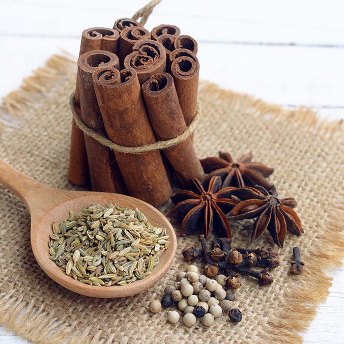 five spices (cinnamon, fennel, star anise, pepper, clove) to make chinese five-spice powder on wooden background