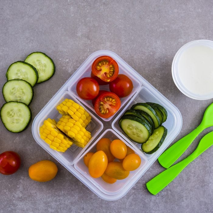 Tasty vegetarian take away food in plastic lunch box on light background.