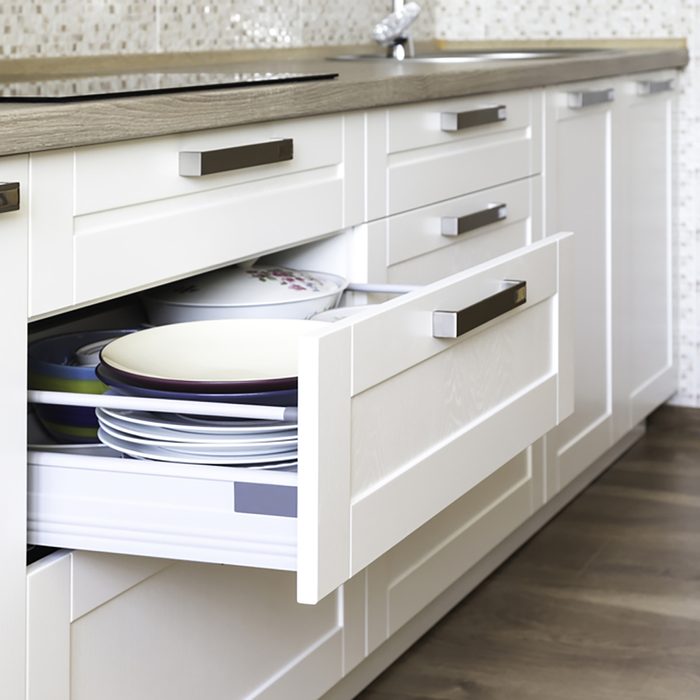 Opened kitchen drawer with plates inside, a smart solution for kitchen storage and organizing.