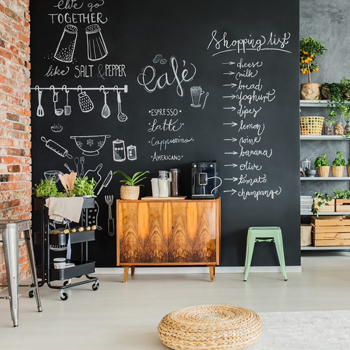 Dining room with chalkboard wall, wooden chest and kitchen cart