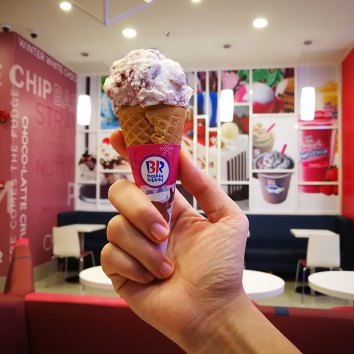 Hand holding Baskin Robbins ice cream cone. Baskin-Robbins is the world's largest chain of ice cream specialty shops and is based in Canton, Massachusetts.