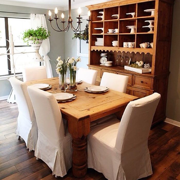 farmhouse style dining room with chairs, chandelier and storage