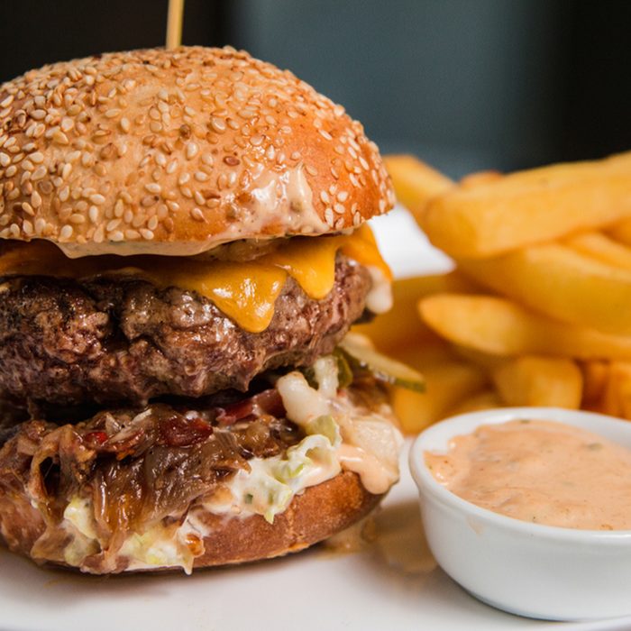 Close up of a tasty burger with sauce and fries