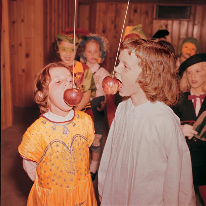 children at a Halloween party eating apples