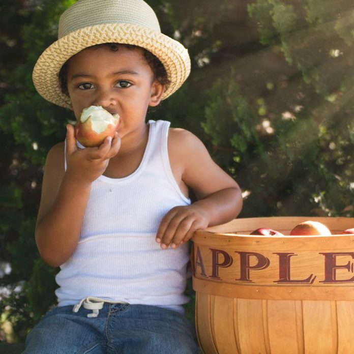 Young boy eating an apple