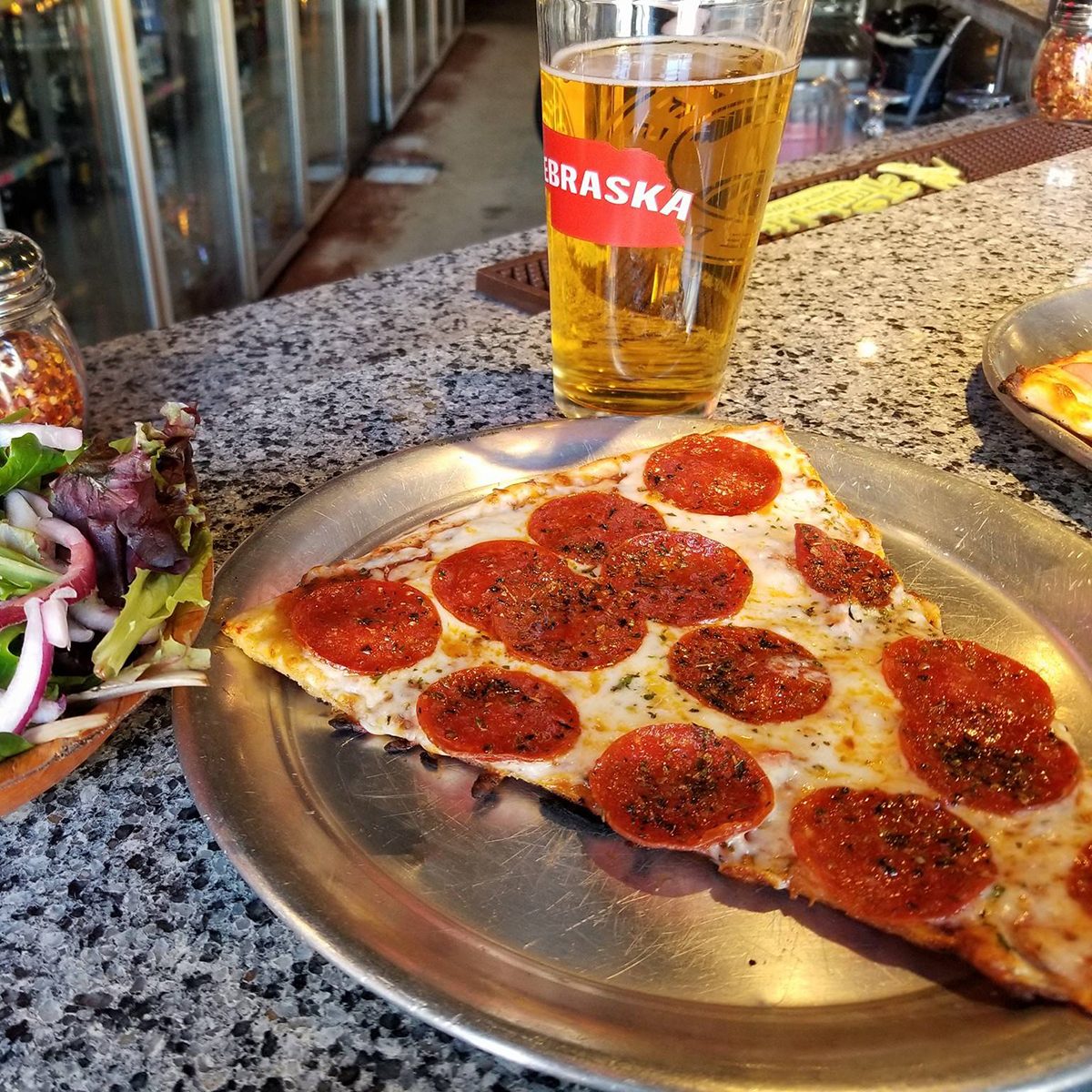 large slice of thin crust pepperoni and cheese pizza from Yia Yia's Pizza and Beer