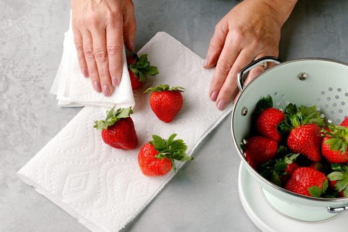 prepping strawberries for chocolate covered strawberries