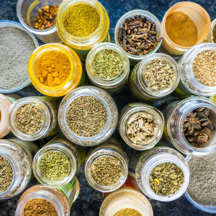 Variety of colorful, different, opened spice jars, from above.