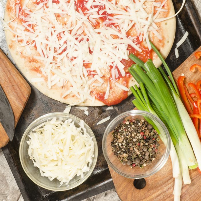 Homemade pizza on baking tray and Ingredients for cooking.