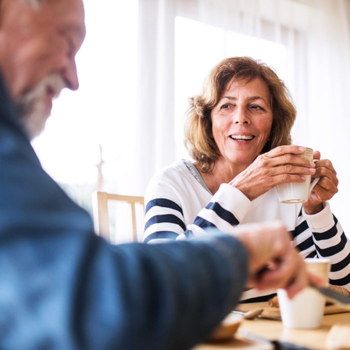 Senior couple eating breakfast at home.