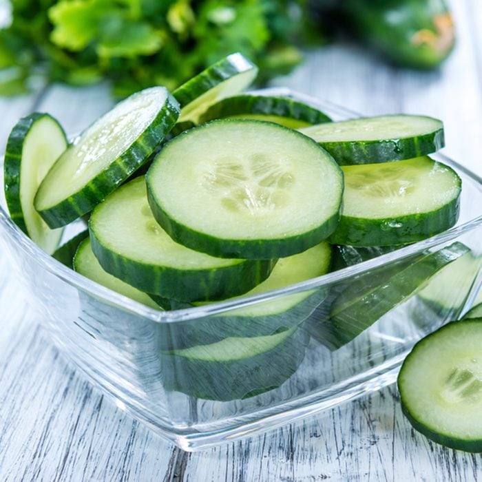 Heap of fresh sliced Cucumbers on an old wooden table