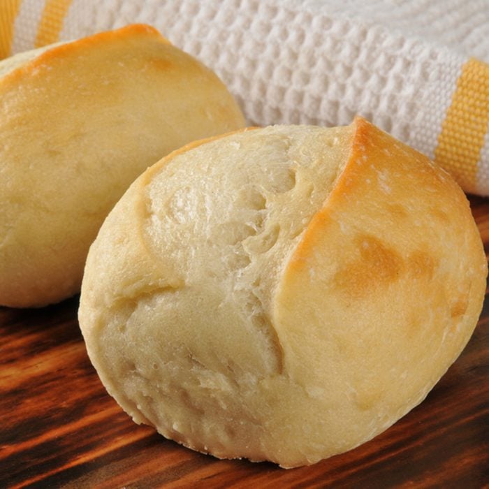 Fresh baked dinner rolls on a cutting board