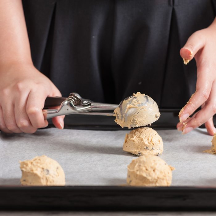 Putting mixed cookie ingredients into tray