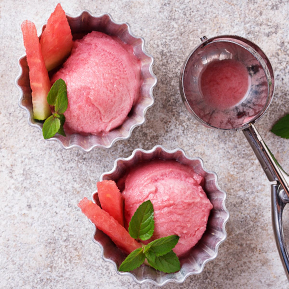 Watermelon ice cream in metal bowls on light background. Top view; Shutterstock ID 1144557173; Job (TFH, TOH, RD, BNB, CWM, CM): Taste of Home
