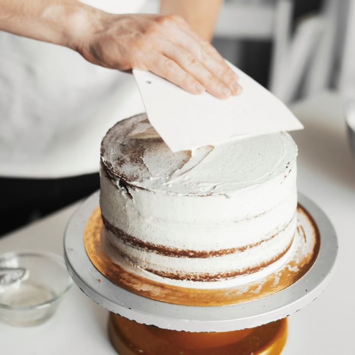 Close up of cook smearing butter cream on chocolate cake.; Shutterstock ID 1170976687; Job (TFH, TOH, RD, BNB, CWM, CM): Taste of Home